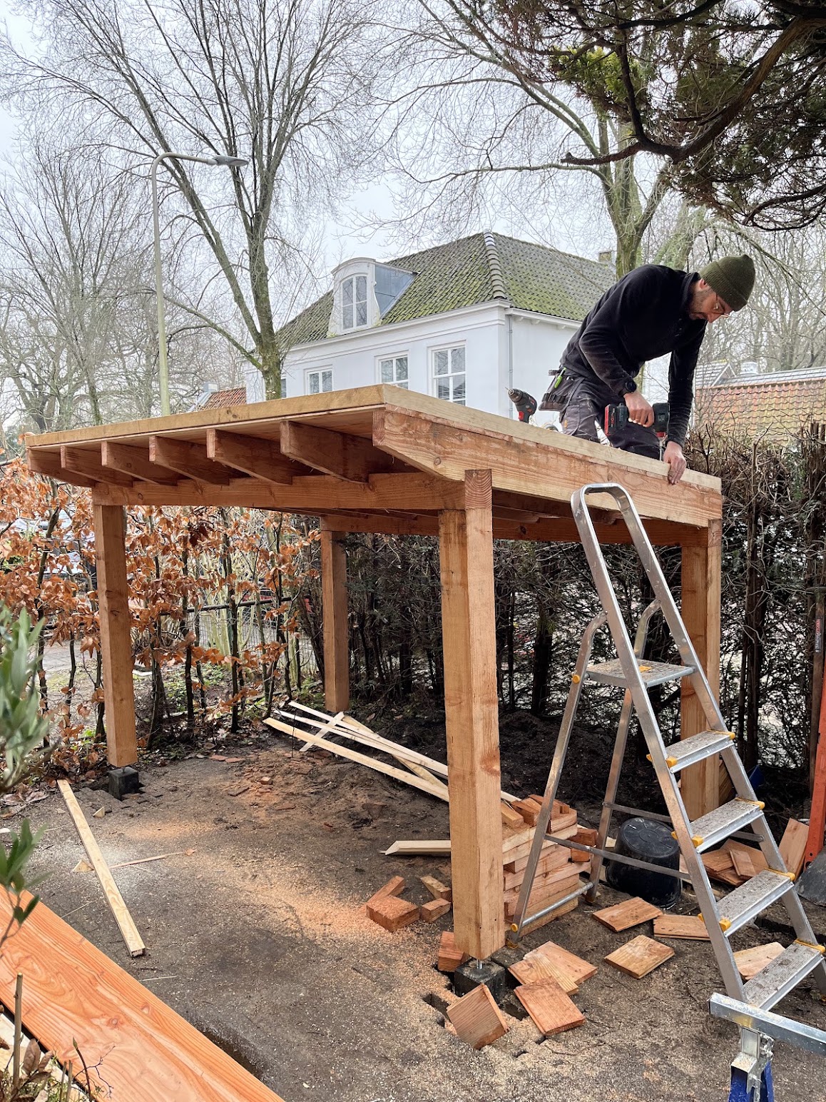 Paul bouwt een houten overkapping op locatie